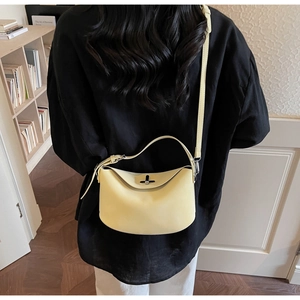 Détail du sac bandoulière crème en cuir grainé montrant la texture douce et le fermoir