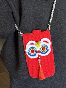 Handmade red knit lion dance phone bag with pearl strap and festive tassel detail
