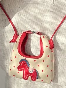 Mini cream handbag with red polka dots and horse applique, featuring a slim red shoulder strap