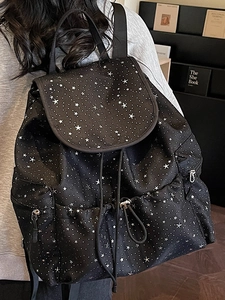 Minimalist black backpack with white star pattern and drawstring closure shown on model