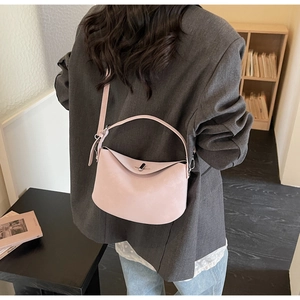 Détail du sac polochon rose pâle montrant la boucle métallique et la texture du cuir