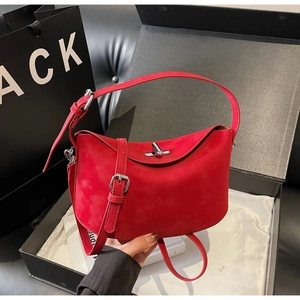 Détail du sac à main en daim rouge avec fermoir argenté dans un coffret cadeau