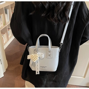 Dettaglio della mini borsa a secchiello celeste con ciondolo a cuore di perle