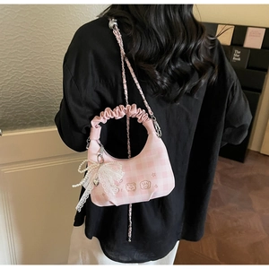 Detail of pink plaid pleated handbag with cute bear embroidery and lace pearl charm accessory