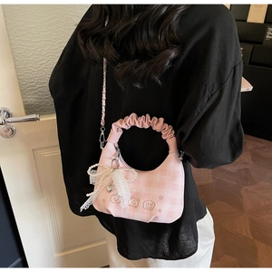 Detail of pink plaid handbag with lace bow, pearl chain and cute bear embroidery