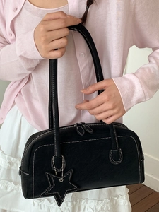 Minimalist black leather handbag with white contrast stitching and star charm detail