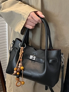 Chic black leather handbag with silver twist lock and retro wooden bead charm accessory