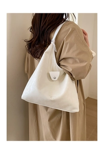 Dettaglio della borsa tote bianco crema con chiusura magnetica e logo stampato