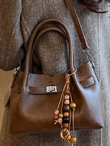 Brown minimalist shoulder bag for women featuring silver lock and wooden bead pendant accessory