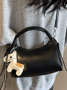Sac bandoulière chic en cuir noir mat avec poignée ronde et breloque cheval