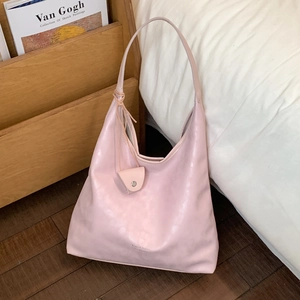 Dettaglio della borsa hobo rosa capiente con un ciondolo portamonete e pelle morbida
