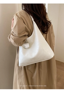 Dettaglio di una grande borsa tote in pelle bianca con trama vintage sulla spalla