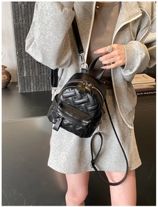 Detail eines schwarzen Mini-Rucksacks mit Herz-Steppmuster und silbernen Metallbeschlägen