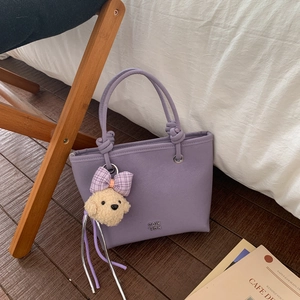 Purple faux leather bucket bag with metal letters and cute plush poodle charm detail
