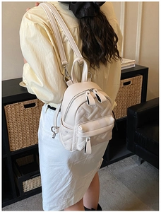 Detail eines hellbeigen gesteppten Herzrucksacks mit hochwertigem Kunstleder und Reißverschluss
