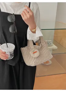 Gros plan du sac à main en crochet beige avec texture tricotée et étiquette faite main