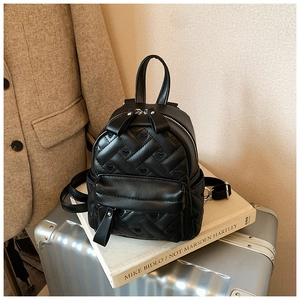 Detail des schwarzen Mini-Rucksacks mit Herz-Rautensteppung auf silbernem Koffer