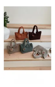 Texture détaillée de sacs à main au crochet faits main aux tons terre avec breloque coeur