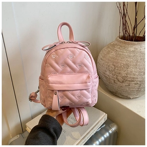 Detail eines rosa gesteppten Mini-Rucksacks mit Herzbestickung und Goldreißverschluss