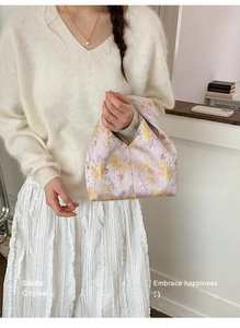 Nahaufnahme der fliederfarbenen Satin-Knotentasche mit Blumenmuster und Studio-Stickerei