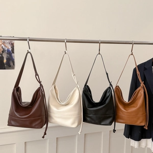 Row of large shoulder bags in dark coffee, cream, black, and caramel faux leather