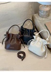 Close-up of knot handles and matte vegan leather texture on drawstring bucket bags