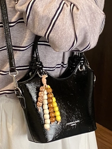 Sac seau noir brillant rétro avec décoration en perles de bois et texture plissée