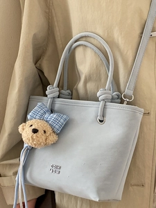 Light blue faux suede bucket bag with bear charm and adjustable shoulder strap