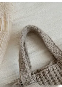 Gros plan sur la poignée épaisse tissée à la main et la texture du sac en tricot beige
