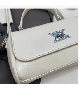 Détail rapproché d'un sac à main en cuir ivoire avec un fermoir en métal argenté unique