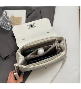 Détail du sac baguette blanc avec boucle K argentée et rangement intérieur multicouche