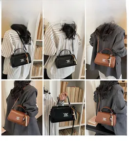 Détails du sac baguette chic avec logo métallique et pendentif en perles de bois unique