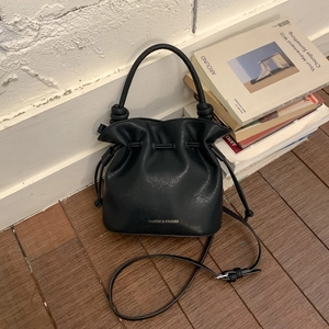 Detailed view of black pleated bucket bag with Favor & Stories logo and drawstring closure
