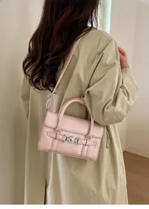 Borsa rosa con motivo coccodrillo e fibbia ad anello argento indossata sopra un trench