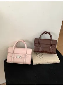 Dettagli di borse rosa e marroni con trama a coccodrillo e fibbie a cuore argento
