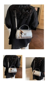 Détail du sac à bandoulière argenté avec breloque en perles et finitions métal