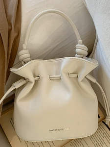 Chic cream leather bucket bag with pleated drawstring and knot handle detail