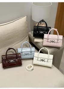 Dettaglio di eleganti borse a mano con trama a coccodrillo in cinque vari colori