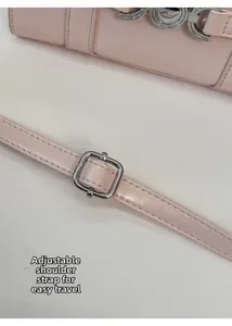Dettaglio della borsa in pelle rosa con tracolla regolabile e fibbia in metallo argento