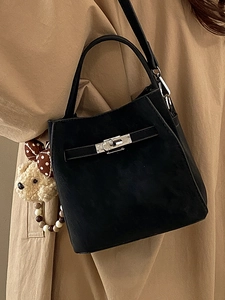 Elegant black suede bucket bag with vintage silver buckle and plush bear charm
