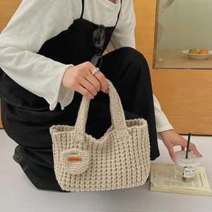 Détail du sac cabas au crochet fait main beige avec pendentif en forme de cœur décoratif