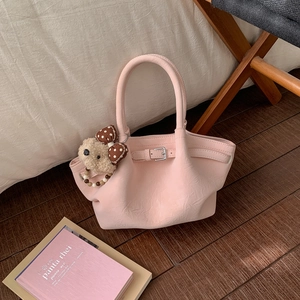Detailed close-up of pink bucket bag featuring a wavy rim and cute teddy bear pendant