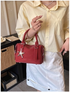 Close-up of red pillow bag with silver star charm in a lifestyle home setting