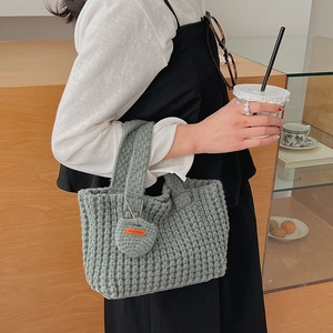 Détail du sac à main en crochet gris clair avec un pendentif cœur fait main au café