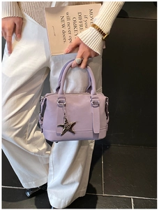 Lavender pillow bag with star pendant shown in a lifestyle model hand-carry scene