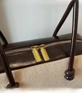 Close-up of smooth dual golden zippers and textured woven fabric on vintage shoulder bag