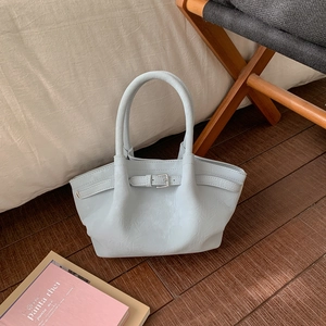 Detail of light blue pleated bucket bag with metal buckle and soft leather texture