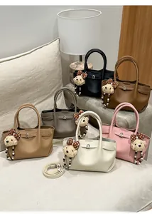 Close-up of textured leather bucket bags in multiple colors with cute bear charms