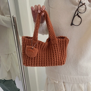 Détail d'un sac à main en maille fait main avec pendentif cœur et étiquette Hand Made