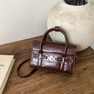 Dettaglio borsa marrone scuro con goffratura coccodrillo e fibbia a cuore in argento